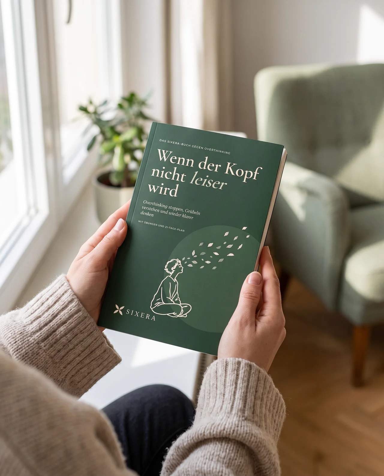 Zwei Hände halten das Buch am Fenster